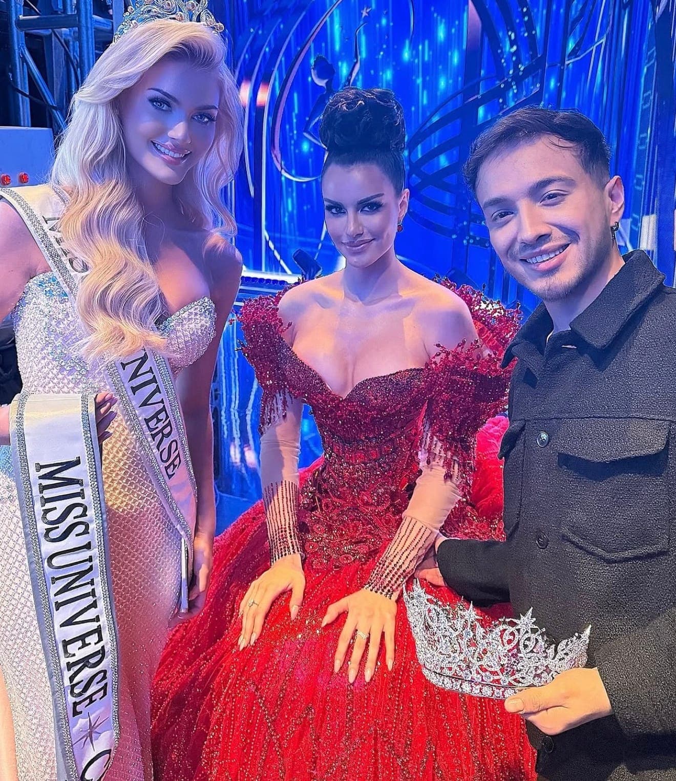 Backstage de Miss Universe: dos reinas con banda y corona junto a un integrante del staff