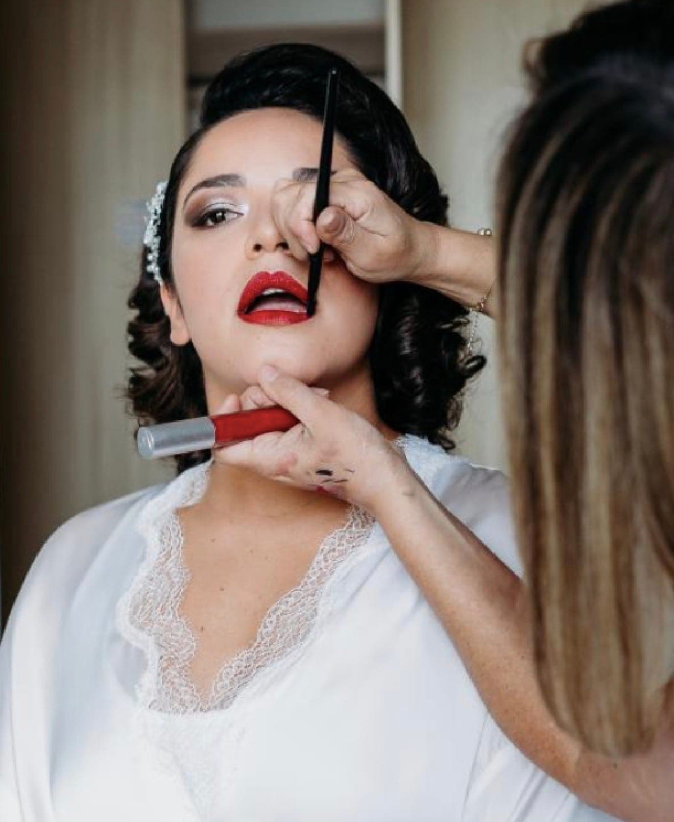 Aplicación profesional de maquillaje de novia en primer plano: rostro, acción técnica y manos con intención